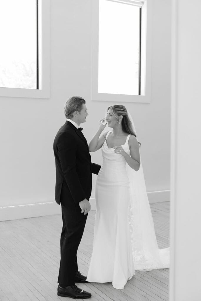 a black and white first look photo with bride and groom